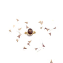 Anello in ottone con borsa del pastore su sfondo rosso