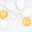 Collana a mezza luna con guscio d'uovo e foglia dorata