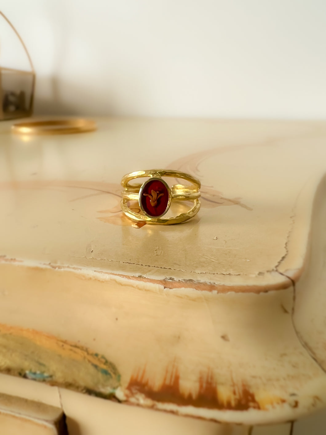 Adjustable ring with three bands and privet flower on a red background