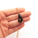 Collana con ciondolo realizzato con fuliggine e foglie d'oro