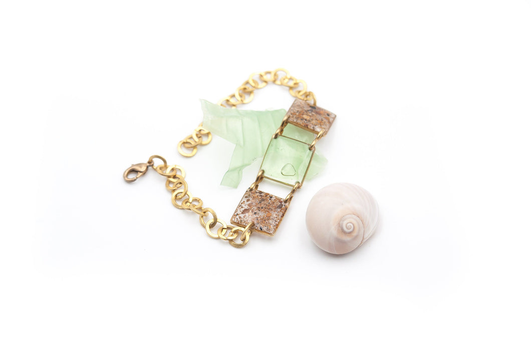 Adjustable brass bracelet with sand and plastic charms