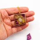 Necklace with resin pendant featuring natural and polluting marine elements