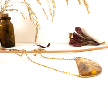 Load image into Gallery viewer, Half moon necklace with pendant with flower cutouts and gold fragments
