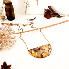 Load image into Gallery viewer, Half moon necklace with pendant with flower cutouts and gold fragments
